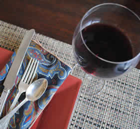 Glass of red wine with silverware and placemat
